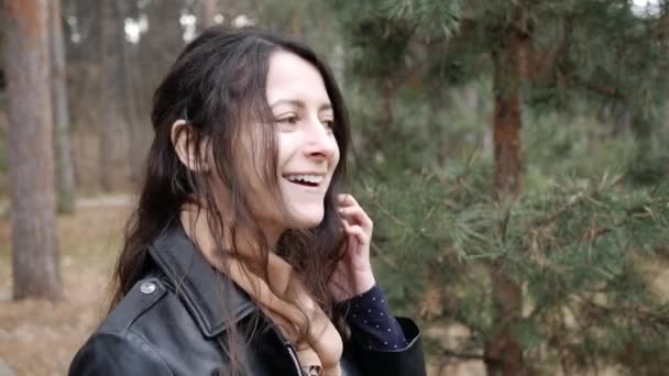Vrouw glimlachend en pratend aan de telefoon tijdens het wandelen in het openbaar park. Ze is blij om beller te horen. — Stockvideo