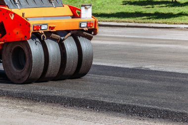 Yol silindiri bir yol inşaatında yeni asfalt yolu inşa ediyor.