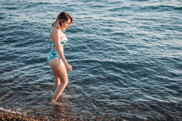 Beautiful young woman goes to the beach in bikini with beautiful — Stock Photo, Image