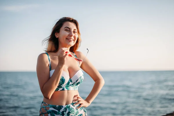 Retrato de una hermosa joven sonriente en gafas de sol y bi — Foto de Stock