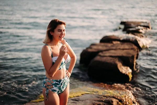 Porträtt av en vacker leende ung kvinna i bikini och solstråle — Stockfoto