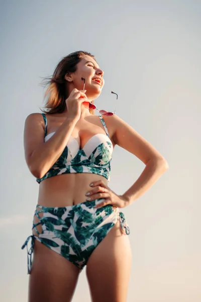 Porträtt av en glad ung kvinna i bikini och solglasögon — Stockfoto