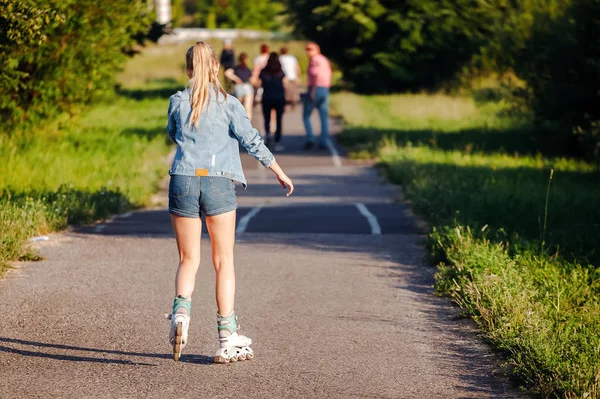 Young woman on roller skates in Park. view from he back — Stock Photo, Image