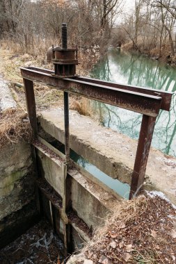 valve dam on river. mechanism for raising bottom shutter of pond