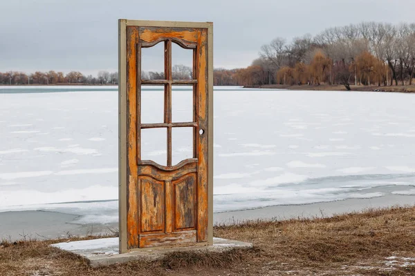 Door on the beach in winter. Access to the beach is closed. door to another world. free-standing door in nature against the backdrop of a frozen lake in winter