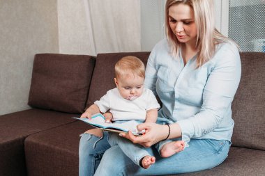 Bebek bakıcısı küçük bir bebekle konuşuyor. Peri masalı okuyorum.