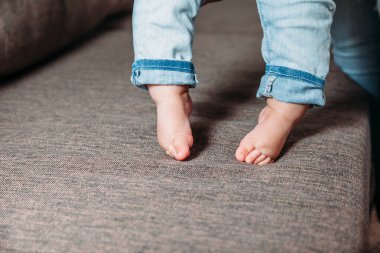 Bebeğin ilk adımları. Bebeğin ayakları ilk adımları atıyor. Yalınayak çocuk bacakları fotoğrafı..