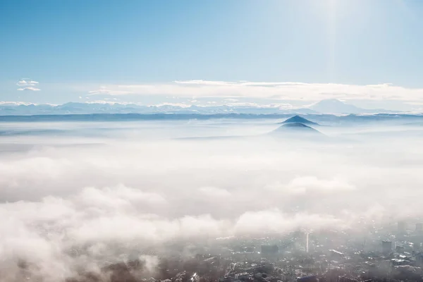 雲の下の雲や街の山々を俯瞰する鳥たち — ストック写真