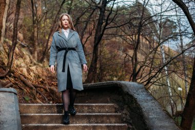 Güz Parkı 'nda montlu güzel kız merdivenlerden iniyor. kopyala 