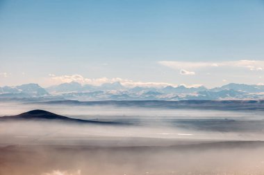 Kuşlar bulutlardaki dağlara bakıyor.