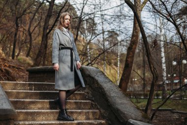 Güz Parkı 'nda montlu güzel kız merdivenlerden iniyor. kopyala 