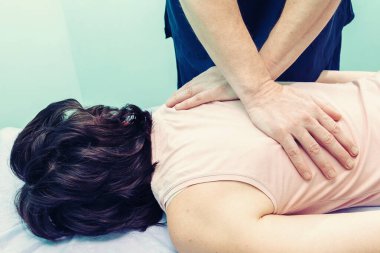 Beyaz erkek, profesyonel doktor sırt sorunu olan bir hastaya masaj yapıyor.