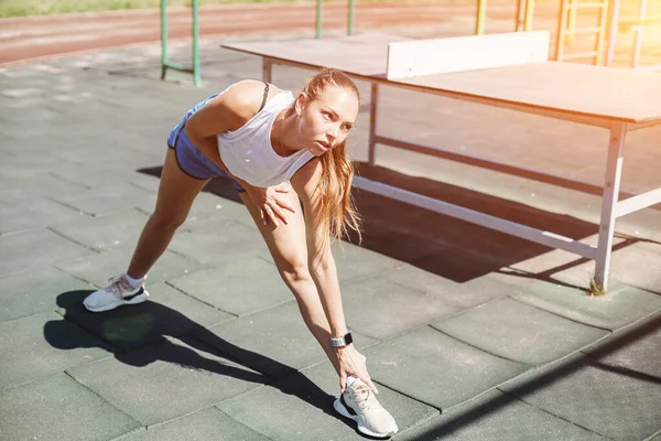 Спортивная молодая блондинка на спортивной площадке занимается спортом — стоковое фото
