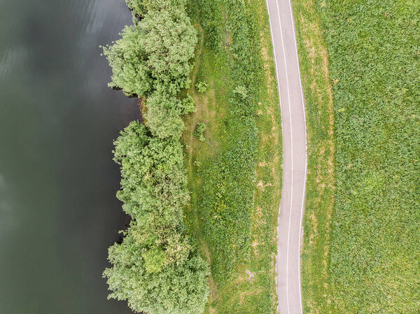 Top view of the road and the trees along the lake