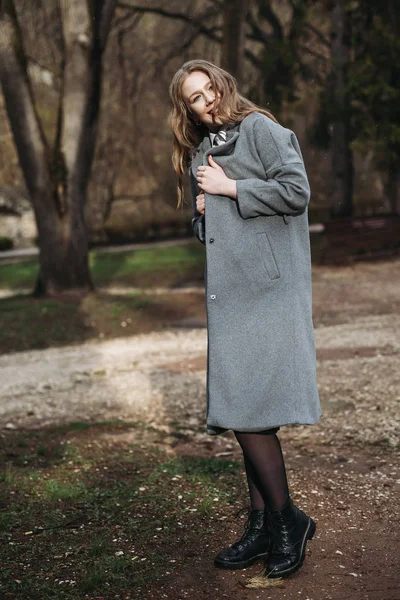 Beautiful young businesswoman in grey coat posing in Park autumn — Stock Photo, Image