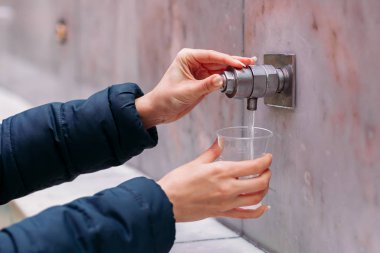 Yessentuki, Stavropol Territory / Russia - February 26, 2019: Drinking gallery of mineral spring Essentuki 17. indoors. young woman holding a glass of mineral water