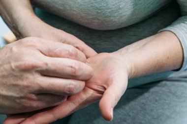 Tıp doktoru hastanın kolunda akupunktur yapar.