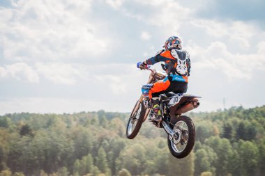 Lebedyanka, Rusya - 25 Ağustos 2019: Rus Motokros Şampiyonası, motosiklet ve motosiklet yarışları off-road off-country. Sporcu mavi gökyüzüne karşı sıçrama tahtasına atlıyor.