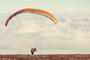 paraglider dağın tepesinde paraşütle atlamaya başlıyor