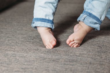 Bebeğin ilk adımları. Bebeğin ayakları ilk adımları atıyor. Yalınayak çocuk bacakları fotoğrafı..