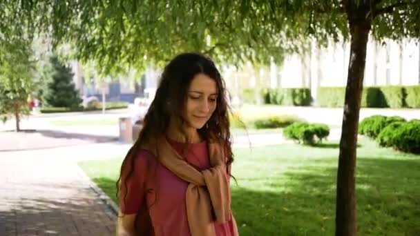 Beautiful young woman in pink T-shirt with sweatshirt on her shoulders rejoices on good day. Joy concept — Stockvideo