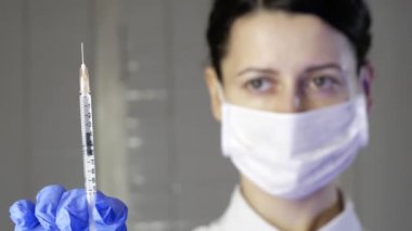 Kadın tıp uzmanı bir hastaya şırınga ile ilaç aşısı gösterdi