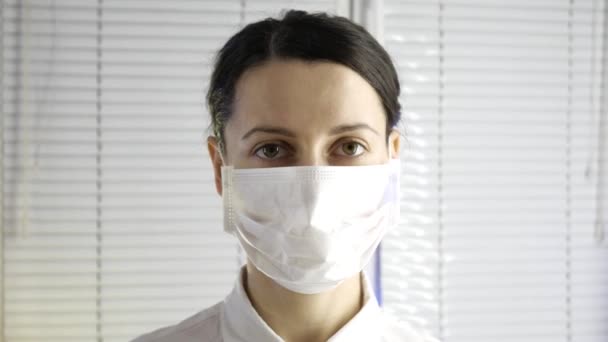 Primer plano de la joven hermosa doctora en máscara médica — Vídeos de Stock
