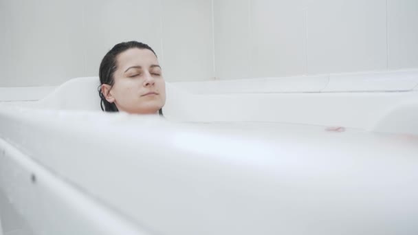 Junge Frau im Badezimmer unter Wasser — Stockvideo