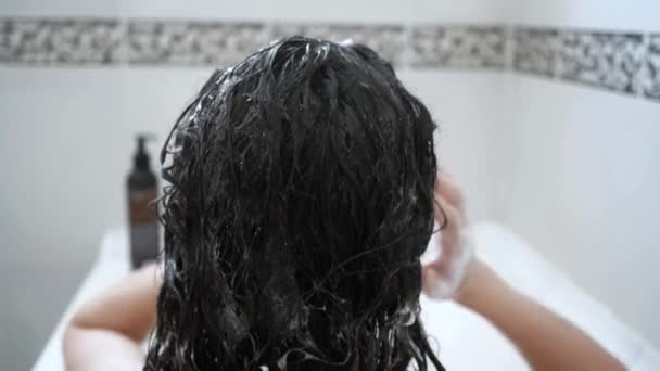 Woman washes her hair with shampoo in shower with, hair care, ceratin mask, rinse shampoo and balm, strong, washing hair — Stock Video