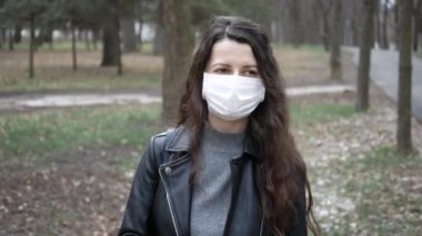 Maske takan ve şehre bakan bir kadın. Sağlık ve tıbbi konsept