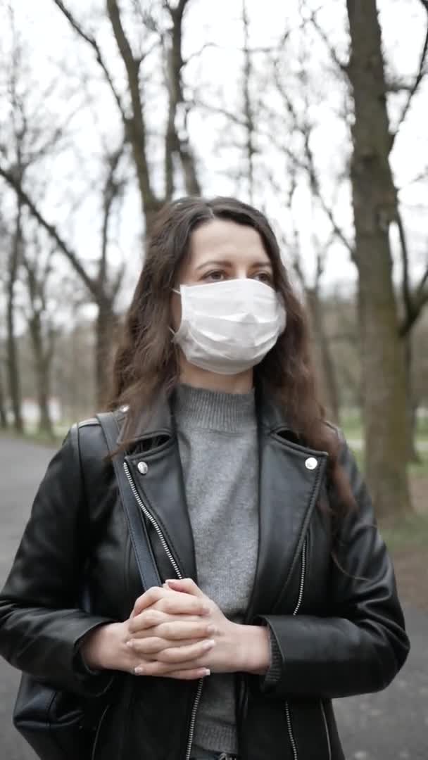 Giovane donna in maschera è a Park in città. Tossisce. coronavirus pandemico. video verticali — Video Stock