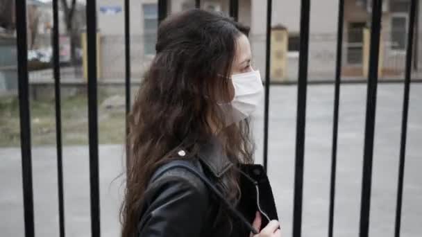 Turistka v ochranné masce kráčí po ulici. ochrana proti virům a bakteriím. Pandemický koronavirus. Koncepce zdraví a bezpečnosti, covid-2019 N1H1 coronavirus, ochrana proti virům — Stock video