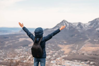 Sırt çantalı bir adam dağın tepesinde.