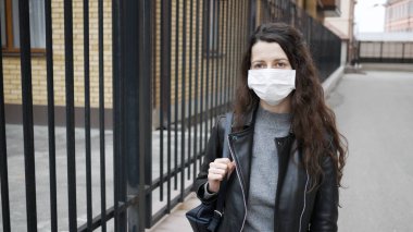 Yüzünde koruyucu tıbbi maske takmış beyaz esmer portresi var. Her yerde grip virüsü ve koronavirüs salgını var..