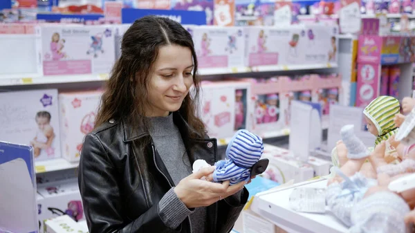 Young Woman Choose Toy Doll Children Store Daughter — стоковое фото