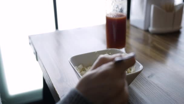 Primer plano de ensalada y un vaso de jugo de tomate en un café. Chica almorzando en un café — Vídeos de Stock