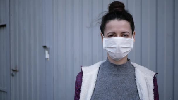 Ung kvinna i latexhandskar och medicinsk mask kontaktlös levererar paket med produkter, varor till klienten under karantänsperioden. livsmedel — Stockvideo