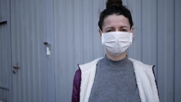 Доставка їжі молода жінка в захисній масці і рукавичках несе сумку з продуктами з магазину. пандемія — стокове відео