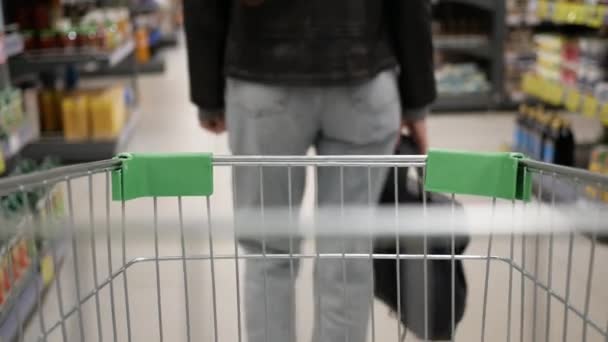 Stilvolle Frau im Supermarkt mit dem Einkaufswagen — Stockvideo