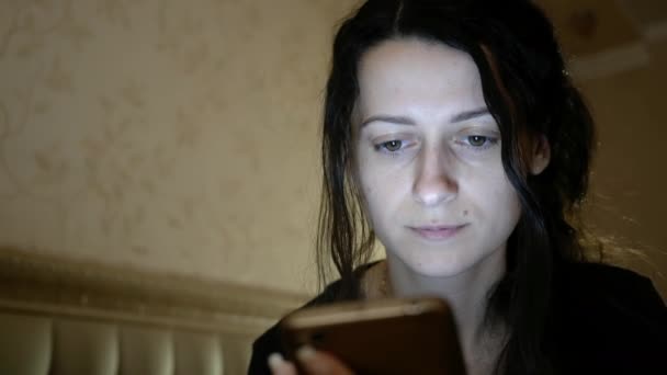 Junge Frau nutzt Smartphone und setzt sich nachts aufs Bett Abschalten. Niedriger Winkel — Stockvideo