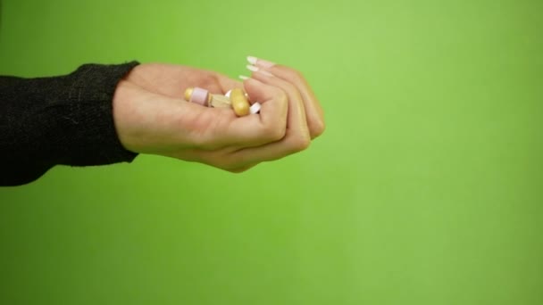Pills, capsules falling from palm of hand on green background in slow motion. Multi-colored tablets are flying. Beautiful drop pills. medical footages, healthy lifestyle, vitamins, drugs — Stock Video