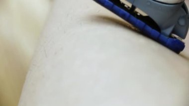 Makro 'nun son derece yakından çekilmiş jileti. Kız bacaklarını jiletle traş ediyor.