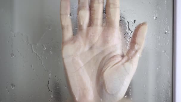 Girl loses consciousness in bathroom. Closeup. Female hand on blurry glass of shower door — Stock Video