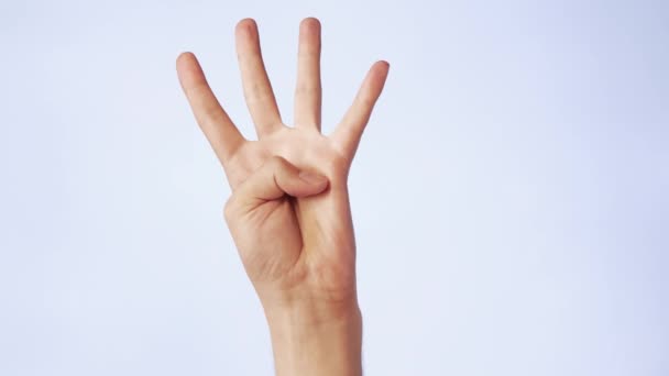 Primo piano mano maschile isolato su uno sfondo bianco quattro dita alzate — Video Stock