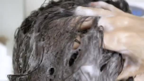 Bruneta žena ve sprše si myje vlasy šamponem zblízka. Koncept čistoty vlasů a těla, hygiena — Stock video