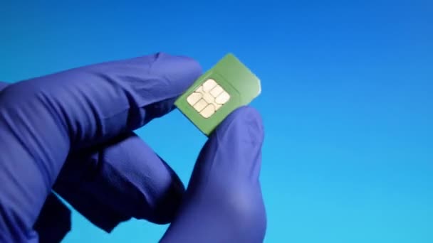 Mini sim card close-up dans les mains des techniciens en gants. Concentration sélective — Video