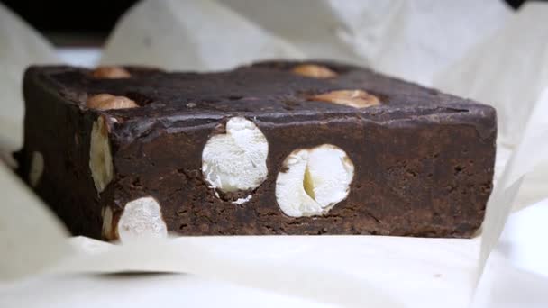 Čokoládová tyčinka s celými lískovými ořechy chutné dezert zblízka — Stock video