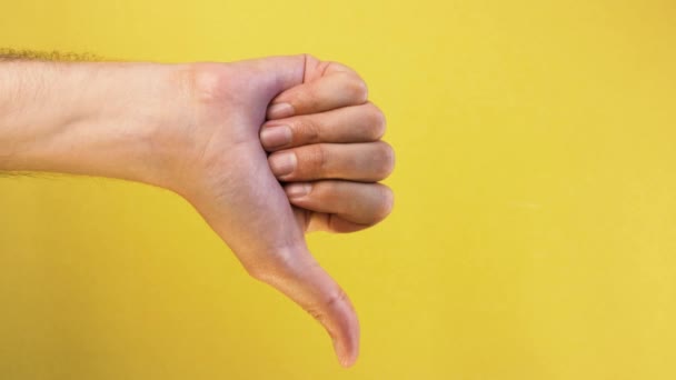 Man hand show thumbs down gesture isolated yellow background — Stock Video