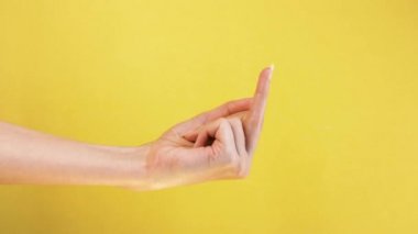 Woman hand showing gesture Middle Finger meaning in western cultures Fuck you or fuck off isolated yellow background