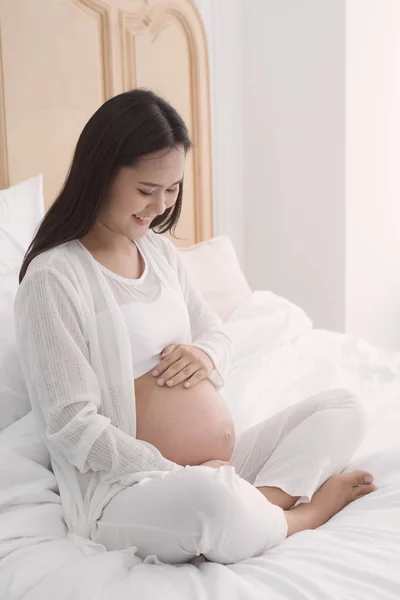 Беременная женщина касается живота. — стоковое фото